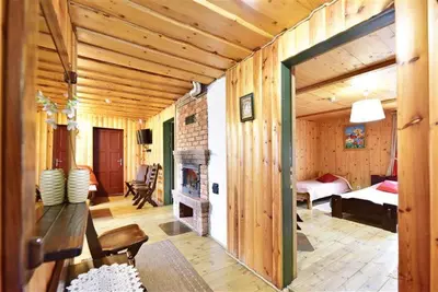a wooden room with a fireplace and a bedroom at Sodyba Sauletekis in Ignalina