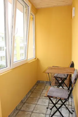 a table and chairs in a room with two windows at Near Park Apartment in Druskininkai