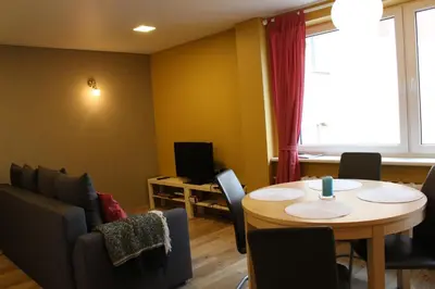 a room with a table and chairs and a window at Near Park Apartment in Druskininkai