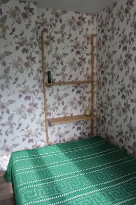 a room with a green bed with flowers on the wall at Near Park Apartment in Druskininkai