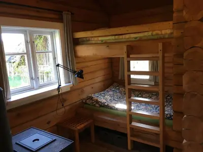 a bedroom with a bunk bed in a log cabin at Vila Migla in Pašekščiai