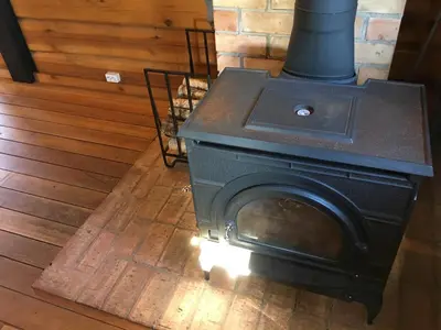 a stove sitting on a wooden floor in a room at Vila Migla in Pašekščiai