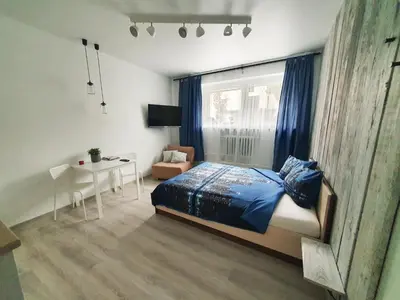 a bedroom with a bed and a table and a window at K-Town - City Center Park Studio in Kaunas