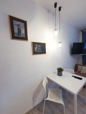 a white dining room with a white table and chairs at K-Town - City Center Park Studio in Kaunas