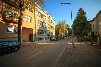an empty street with cars parked on the side of a building at K-Town - City Center Park Studio in Kaunas