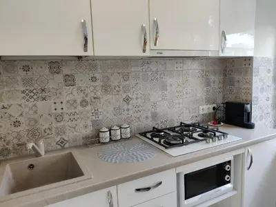 a kitchen counter with a stove and a sink at Apartment Dalyce in Šiauliai