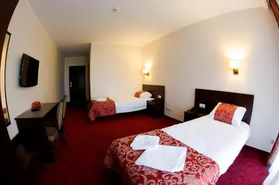 a hotel room with two beds and a desk at Rezidencija Grįžulo ratai in Sasnava