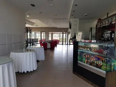 a restaurant with white tables and a drink cooler at Rezidencija Grįžulo ratai in Sasnava
