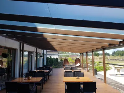 a restaurant with tables and chairs and windows at Rezidencija Grįžulo ratai in Sasnava