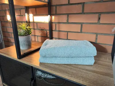 a stack of towels sitting on top of a table at Lampedziai Apartment in Kaunas