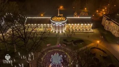 a large building with a clock on it at night at Lampedziai Apartment in Kaunas