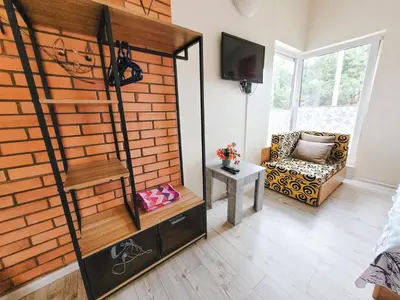 a living room with a brick wall and a chair at Lampedziai Apartment in Kaunas