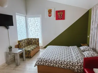 a small bedroom with a bed and a chair at Lampedziai Apartment in Kaunas