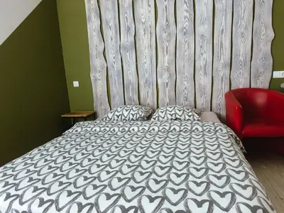 a bedroom with a bed and a red chair at Lampedziai Apartment in Kaunas