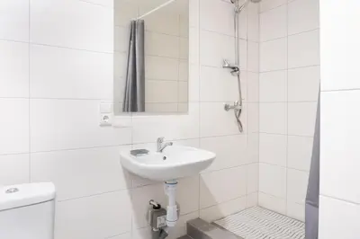 a white bathroom with a sink and a shower at KAUNO JACHTKLUBAS Baltosios Burės in Kaunas