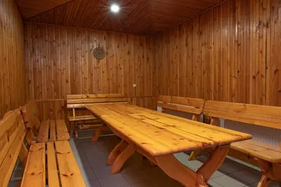 a dining room with wooden tables and benches at KAUNO JACHTKLUBAS Baltosios Burės in Kaunas