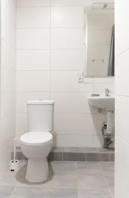 a white bathroom with a toilet and a sink at KAUNO JACHTKLUBAS Baltosios Burės in Kaunas