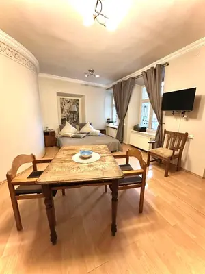 a living room with a table and a bed at Mini Home Vilnius Old Town in Vilnius