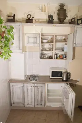a small kitchen with white cabinets and a microwave at Mini Home Vilnius Old Town in Vilnius