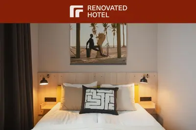a hotel room with a bed with a picture on the wall at Corner Hotel in Vilnius