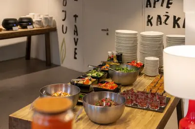 a table with bowls of food and plates on it at Corner Hotel in Vilnius