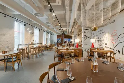 a restaurant with tables and chairs in a room at Corner Hotel in Vilnius