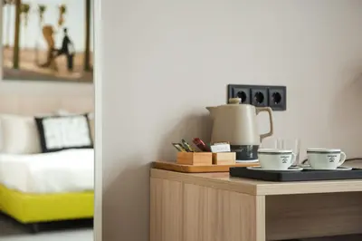 a table with two coffee cups on it next to a bed at Corner Hotel in Vilnius