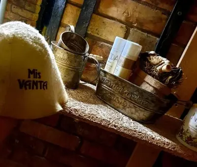 a shelf with buckets and candles on a brick wall at Sveciu namelis in Šiauliai