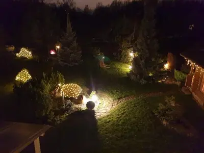 a garden lit up at night with christmas lights at Sveciu namelis in Šiauliai