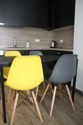 a kitchen with four yellow chairs and a counter at Smartflat & New apartment city center in Kaunas