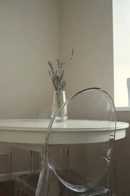 a clear chair sitting next to a table with a vase at Smartflat & New apartment city center in Kaunas