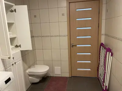 a small bathroom with a toilet and a door at Ados apartamentai in Druskininkai