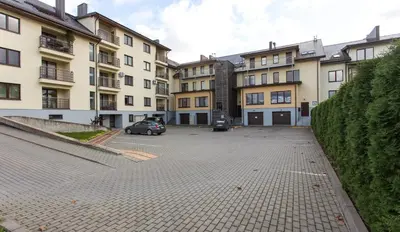 a car parked in a parking lot in front of buildings at Ados apartamentai in Druskininkai