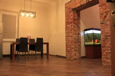 a dining room with a table and a brick wall at Apartamentai Kauno centre in Kaunas