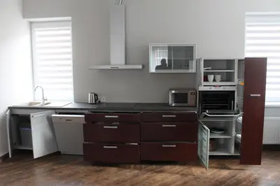 a kitchen with brown cabinets and a counter top at Apartamentai Kauno centre in Kaunas