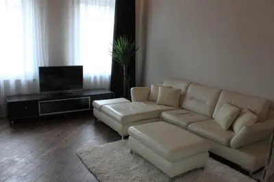 a living room with a couch and a tv at Apartamentai Kauno centre in Kaunas