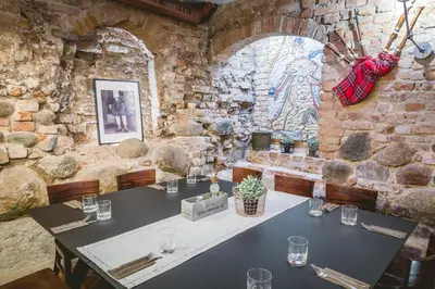 a restaurant with a table in a stone wall at Grėjaus Namas in Kėdainiai