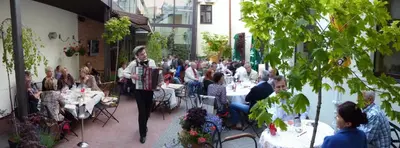 a woman is playing an accordion in a restaurant at Grėjaus Namas in Kėdainiai