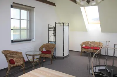 a waiting room with chairs and a table and shelves at Villa Traku Terasa in Trakai