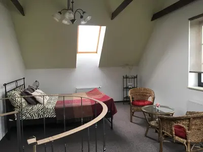a bedroom with a bed and a table and a window at Villa Traku Terasa in Trakai