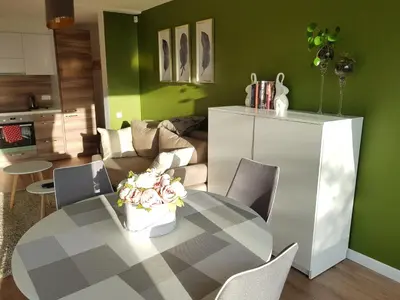 a living room with a table and a couch at Felix Apartment Free parking in Vilnius