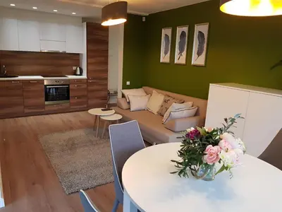 a living room with a couch and a table with flowers at Felix Apartment Free parking in Vilnius
