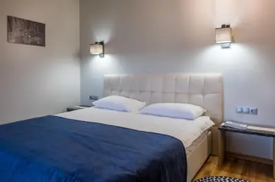 a bedroom with a large bed with a blue blanket at Žvejų užeiga in Šiauliai
