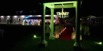 a green gazebo with a chandelier in the night at Žvejų užeiga in Šiauliai