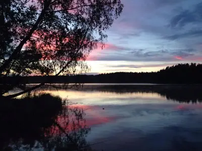a view of a lake with a sunset in the background at Asvejos slenis in Sužionys