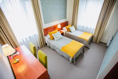 a hotel room with two beds and a table at Žuvėdra in Ignalina
