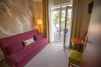a living room with a purple couch and a table at Žuvėdra in Ignalina
