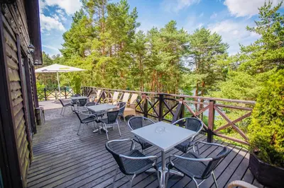 a wooden deck with tables and chairs on it at Žuvėdra in Ignalina