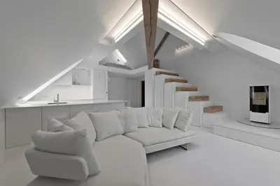 a white living room with a white couch and stairs at City Entrance Apartment in Vilnius