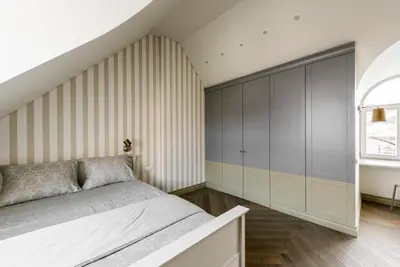 a bedroom with a bed and a wall of cabinets at City Entrance Apartment in Vilnius